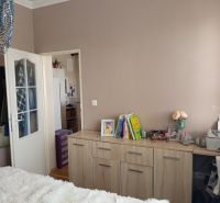 A bright bedroom with a chest of drawers with a wood decor in a 3-room apartment.