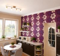 A kitchen in a 3-room apartment with purple wallpaper and a wooden decor floor.