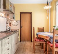 A kitchen in a 3-room apartment with wooden decor and colorful placemats.
