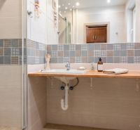 A bathroom in a 3-room apartment with a sink and decorative tiles on the wall.