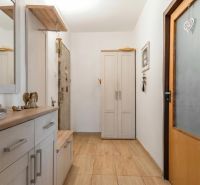 A hallway in a 3-room apartment with a floor featuring a wooden decor and a light-colored wardrobe.