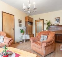 Living room in a 3-room apartment with comfortable armchairs and a wooden decor floor.