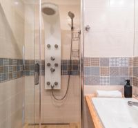 Shower enclosure with a massage jet, modern tiles, and a sink in a 3-room apartment.