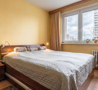Bedroom in a 3-room apartment with a bed and a wooden decor floor.