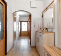 A hallway in a 3-room apartment with wood decor on the furniture and floor.