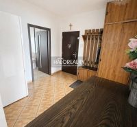 Hallway in a 3-room apartment with a wood-patterned floor and furniture.