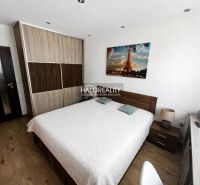 A bedroom in a 3-room apartment with a wardrobe, bed, and wooden decor flooring.