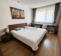 Bedroom in a 3-room apartment with wooden floor decor and a large window.