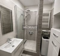 A bathroom in a 3-room apartment with a shower, a washing machine, and a mirrored cabinet.