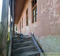 A worn staircase of an older peculiar property in Heľpa, with cracked plaster.