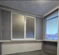 Interior of a family house with plastic windows and blinds, gray walls.