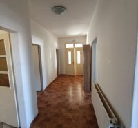 A narrow hallway with a tiled floor and light-colored walls in a family house.