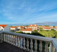 View from the terrace of a holiday apartment in Brač to the sea and rooftops of houses.