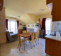 Kitchen in a holiday apartment with a dining table and light-colored walls.