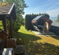 In the garden of the cottage near Ilava, there is a gazebo and a swing surrounded by greenery.