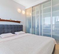 Bedroom in a 2-room apartment with a sliding wardrobe and a wooden decor floor.