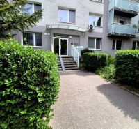 The entrance to the apartment building on Čmelíkova Street in Bratislava - Ružinov surrounded by greenery.