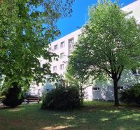 An apartment building on Vrbovská Street in Piešťany surrounded by greenery with benches for seating.