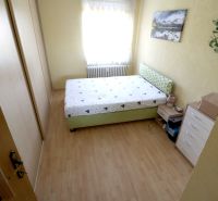 Bedroom with a double bed, wardrobe, and wooden decor flooring in a 2-room apartment.
