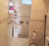 Bathroom with a bathtub and toilet in a 3-room apartment with tiles.