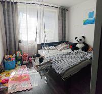 Children's room in a three-room apartment with a wooden decor floor, a hammock, and toys.