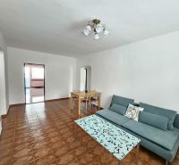 Living room of a 3-room apartment with a sofa, coffee table, and dining table.