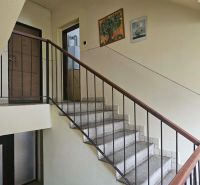 The staircase in the apartment building, leading to the door of a 3-room apartment, is adorned with paintings.