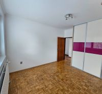 A room with a wooden floor design, a built-in wardrobe, and a large window, 3-room apartment.