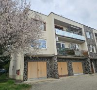 Sídlisko Jelenecká in Nitra with a blooming tree and an apartment building, suitable for a 3-room apartment.