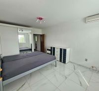 A bedroom with a tiled floor, a bed, and a built-in wardrobe in a 3-room apartment.