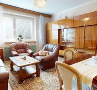Living room in a family house with a sofa set, furniture with a wooden decor, carpets.