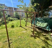 The garden of a family house on Hurbanova Street in Trenčín with a swing and greenery.