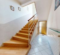 Staircase with wood-patterned flooring in a family house and a radiator in the hallway.