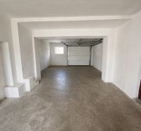 A garage with white walls and a concrete floor in a family house.