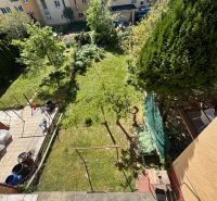 A garden with trees and a lawn, surrounded by buildings on Hurbanova Street in Trenčín.