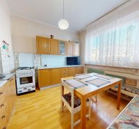A kitchen in a family house with a wooden decor floor and a dining area.