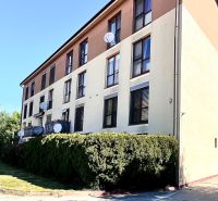 A building in Bernolákovo with 3-room apartments, satellites on the facade, green surroundings.
