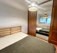 A bedroom in a 3-room apartment with a double bed and a wardrobe with sliding doors.
