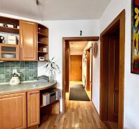 A kitchen in a 3-room apartment with a wooden decor floor and green tiles.