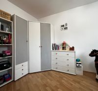 Children's room in a 3-room apartment with a wooden decor floor, toys, and white furniture.