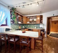 The kitchen of a 3-room apartment with a wooden decor floor and green glass mosaic.