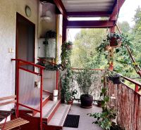 A balcony with plants in a 3-room apartment in Bernolákovo, view of greenery.
