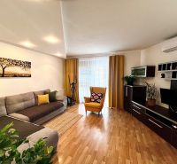 Living room in a 3-room apartment with a comfortable couch and a wooden decor floor.