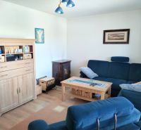Living room in a family house with a blue sofa and a wooden decor floor.