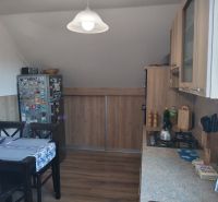 A kitchen in a family house with a dining table and a wooden decor floor.