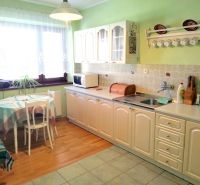 A kitchen with a dining table and a wooden decor floor in a family house.
