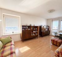 Living room with wood-patterned flooring, a sofa set, and display cabinets in a three-room apartment.