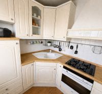 A kitchen in a 3-room apartment with a wooden decor tray and white cabinets.