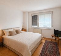 A bedroom with a double bed, nightstands, and a wooden decor floor in a 3-room apartment.