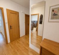 Interior of a 3-room apartment with a wooden decor floor and wooden doors.